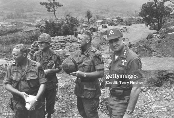 General Rosson and General John Tolson and two of their men survey the scene from a command post stand during the Vietnam war.