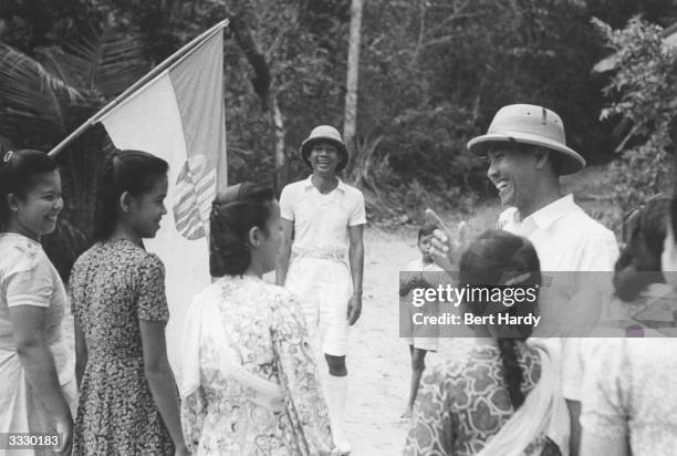 Indonesian statesman Achmed Soekarno , president of Indonesia, talking and laughing with people during an informal tour of the country. Original...
