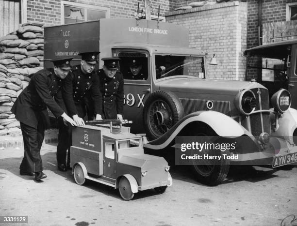 Model fire tender made by members of the London AFS from bomb debris is shown alongside the real thing.