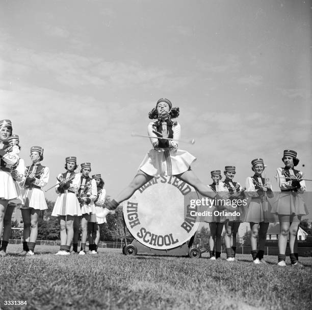 High leap and split in front of the bass drum, by an American baton twirler from Hempstead high school.