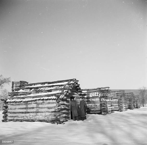 Log cabins in the snow at Valley Forge, Pennsylvania, the winter headquarters of George Washington's Army from 1777 to 1778 during the American...