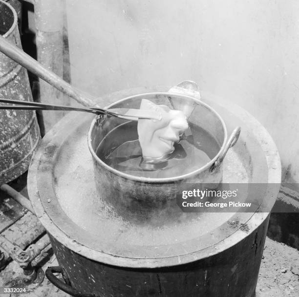 Part of a waxwork's face being lowered in to a melting pot at Madame Tussaud's waxworks museum, London.