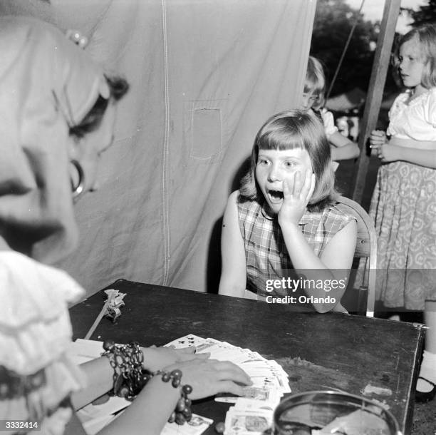 Schoolgirl at the Mamoroneck Methodist Church Lollipop Fair in New York receives some unexpected news from a fortune teller at the fund raising event.