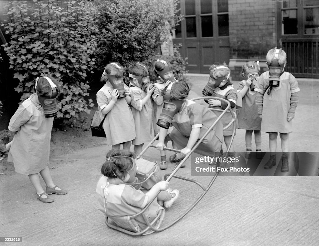 Nursery school children play wearing gas masks during World War II. Photo - Getty