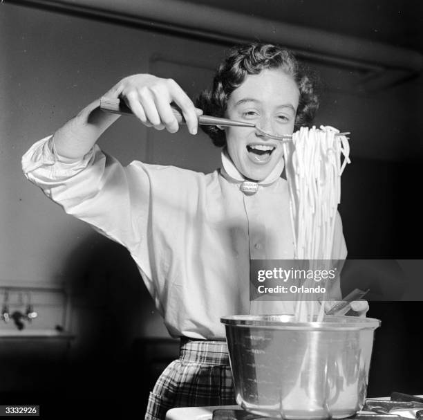 Pupil at Mackin High School, Washington DC, in the USA lifts spaghetti from a pan as she takes part in a home-making training course.