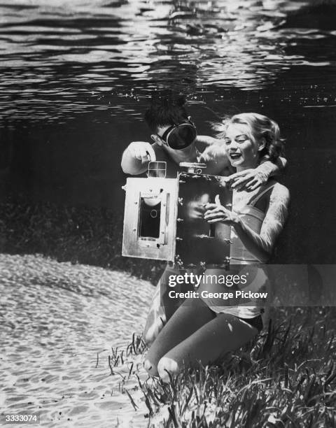 Secretary and part time model Ginger Stanley is shown how an underwater camera works at Silver Springs, Florida.