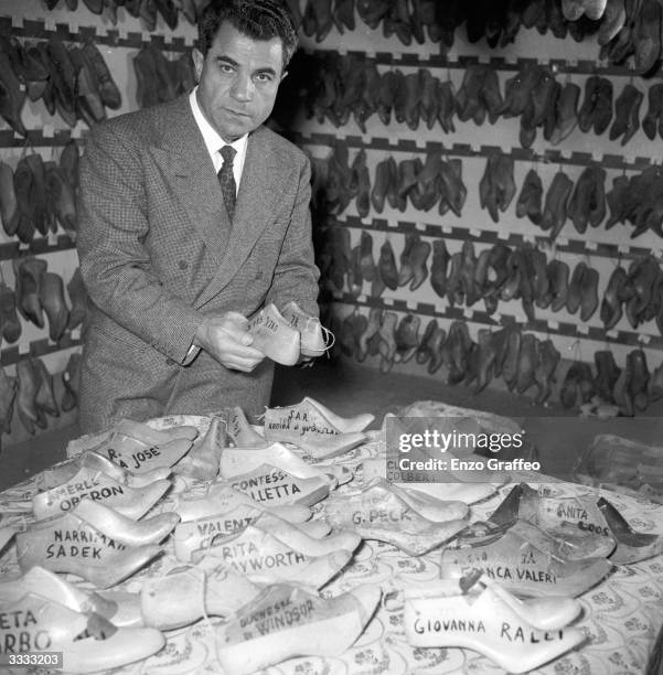 Italian shoemaker Salvatore Ferragamo , who designs footwear for royalty and film stars, with lasts of all the shoes he has made in his shop in...