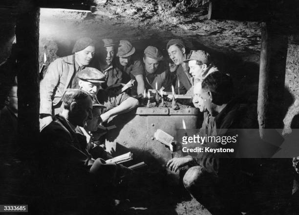 The Rev RN Timms and local Methodist minister the Rev G Hunt conduct a Christmas Carol Service 200 feet below ground for a group of coal miners at...