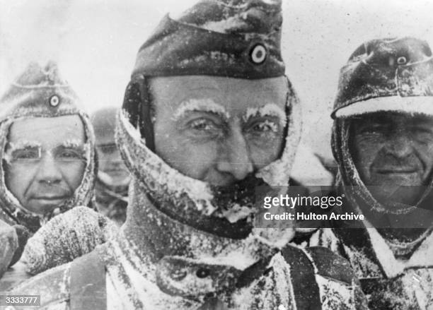 Three German soldiers covered in snow and ice during winter on the Eastern front.