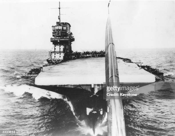 Deck of aircraft carrier USS Saratoga taken from a newly airborne plane the tail of which can just be seen.