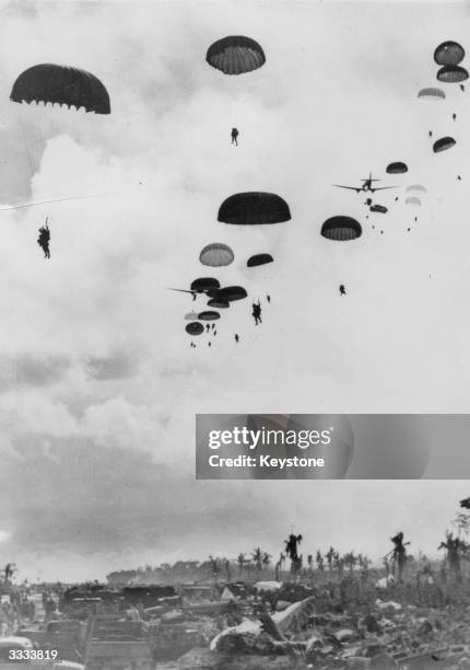 American paratroopers floating down onto a beachhead in support of Allied landings off the north coast of New Guinea during World War II.