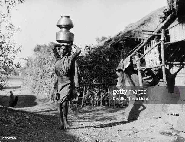 Woman of the Untouchables caste carrying two pots on her head.