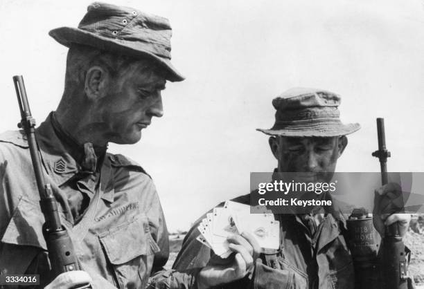Two US Marine sergeants getting a supply of Ace of Spades cards, known as the 'death cards' which the reconnaissance forces leave as a warning to the...