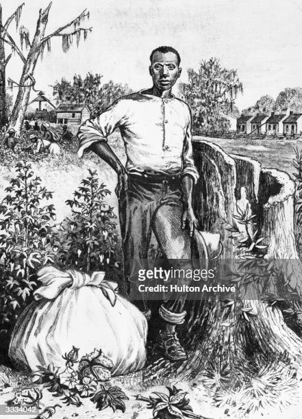 Black man in the Southern USA with a bundle at his feet, in the background enslaved people are at work picking cotton. Southern Industry - .