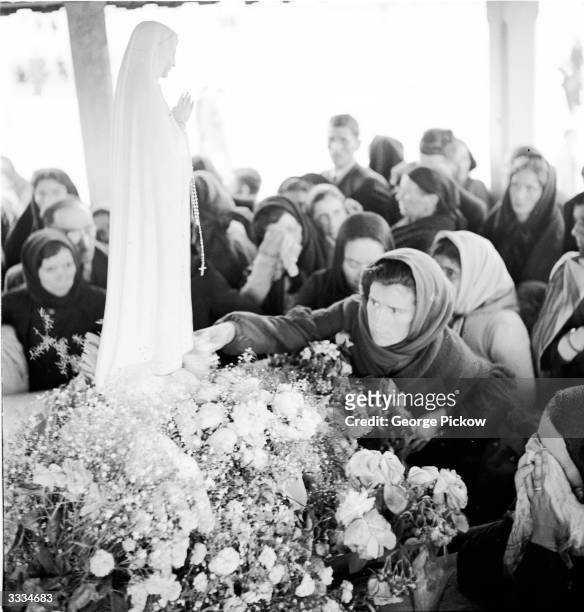 The statue of the Virgin of Fatima is be-decked with flowers at the top of the steps of the Basilica at Fatima, Portugal, in preparation for its...