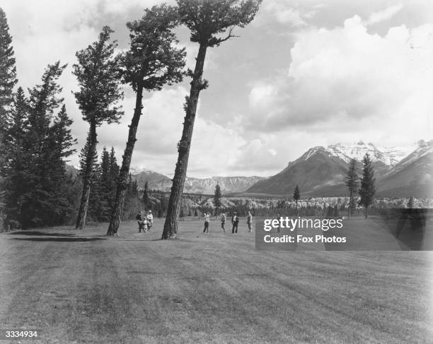 Golfers on the fairway of the 16th Green, by the Three Sentinels, on the Banff Springs golf course.