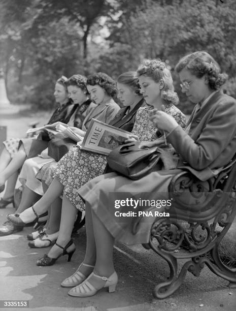 Miss Jacqueline Cochrane, the first woman to pilot a bomber over the Atlantic, reads Time magazine in the gardens at Embankment, London.