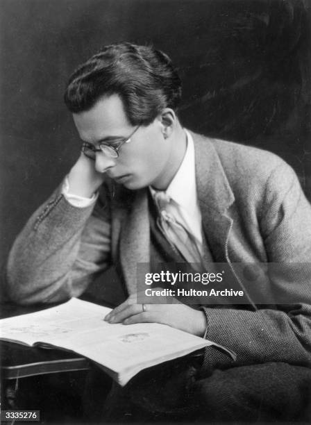 English novelist Aldous Leonard Huxley reading a book.