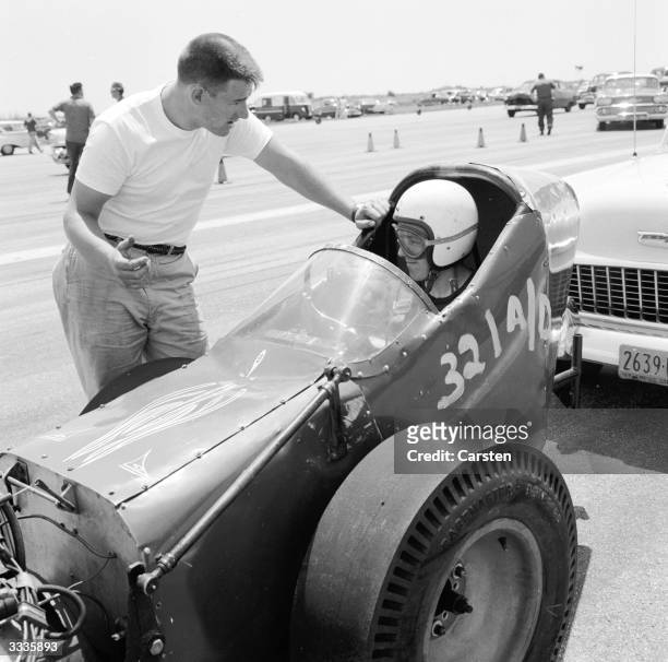 Driver Jack Sutherland from Huntington, Long Island, driving a supercharged Chrysler dragster talks to his pit man at the Pre National Championship...