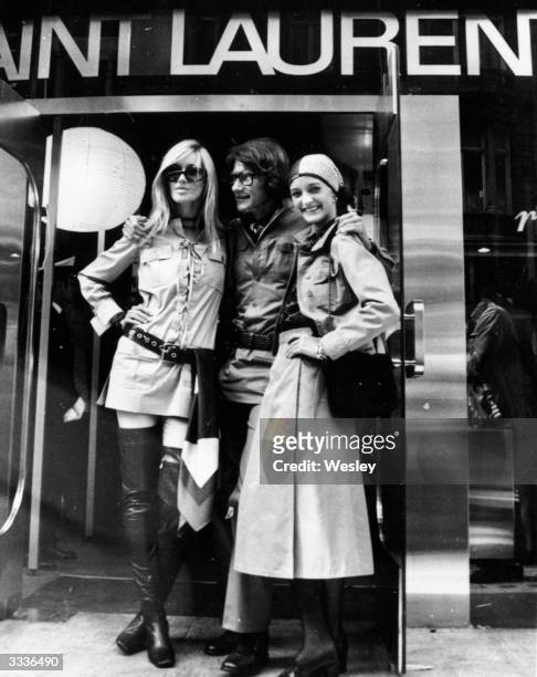 The French couturier Yves Saint Laurent is flanked by Betty Catroux and Loulou de la Falaise outside his new shop in New Bond Street, London.