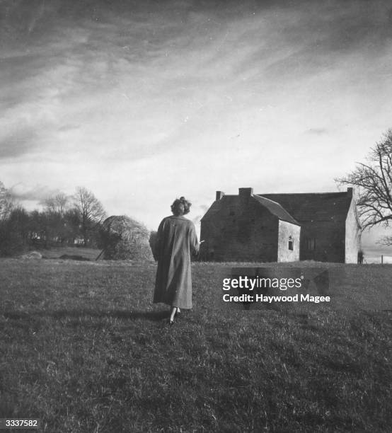 Woman walks through the grounds of an Irish castle. Original Publication: Picture Post - 5004 - Ireland's Castles: Grandeur In Decline - pub. 1950