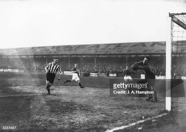 Cann, the Plymouth goalkeeper, diverts Scott's header, as Brentford play Plymouth Argyle in a third round FA Cup tie at Brentford, London.