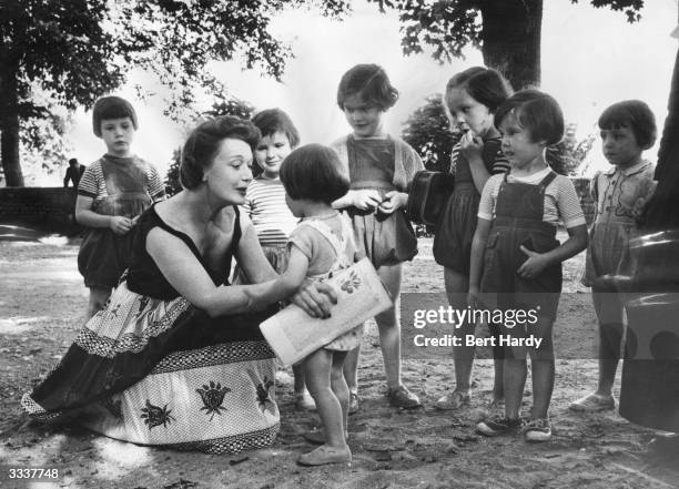 French stage actress Edwige Feuillere with a group of Parisian children visiting the village of Beaujency, Touraine, on the banks of the Loire....