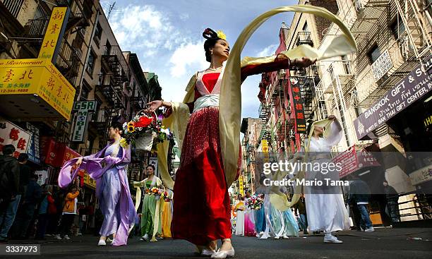 Falun Gong followers dance as they parade through Chinatown April 10, 2004 in New York City. Thousands marched in, and attended, the parade which was...