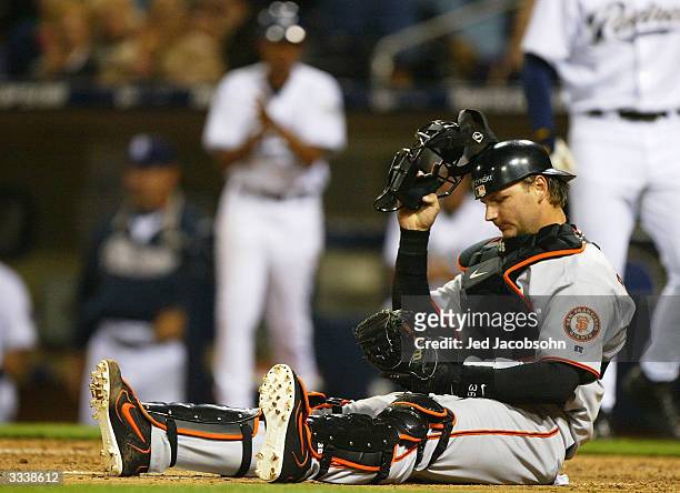 Pierzynski of the San Francisco Giants sits on the ground after Brian Giles of the San Diego Padres scored the go ahead run on a Jay Payton fielder's...