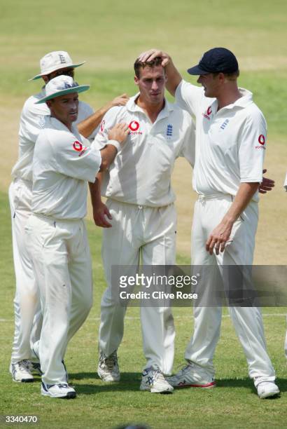 Subdued Simon Jones is congratulated by team-mates after taking the wicket of Ricardo Powell during day two of the 4th Test match between the West...