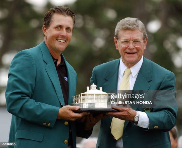 Phil Mickelson of the US receives trophy for winning the Masters Golf Tournament from Augusta National Chairman Hootie Johnson at the awards ceremony...