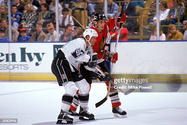 Defense Keith Brown of the Chicago Blackhawks fights for position with Center Wayne Gretzky of the Los Angeles Kings during a game at the Great...