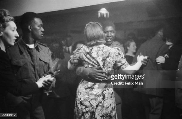 African-American GI dancing with a white girl at the Bouillabaisse Club in London's New Compton Street, Soho, 17th July 1943. Picture Post - 1486 -...