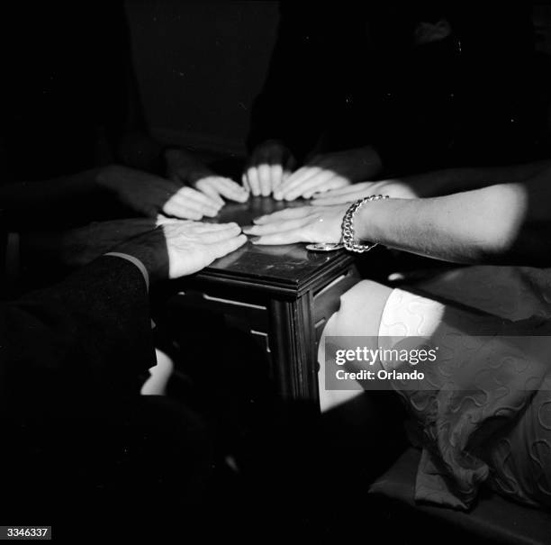 Medium is caught on camera 'tipping' a table with her knee during a seance.