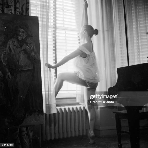 Barbara, a model, looks out of her apartment window, and is captured in soft-focus.