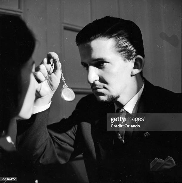 Hypnotist at work with a fob watch.