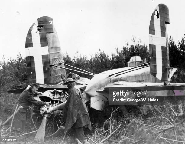 Royal Air Force officers examine a wrecked Italian bomber which was brought down near a forest in the village of Bromeswell in Suffolk.