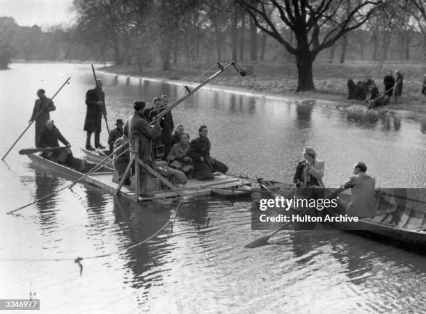 Actors Celia Johnson and Trevor Howard row across a lake followed by a film crew on a floating platform, during a take for the David Lean production...