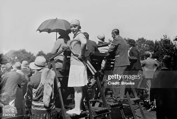 German tennis champion Cilly Aussem climbs on a chair to see play at during a reception for overseas players given by the International lawn Tennis...