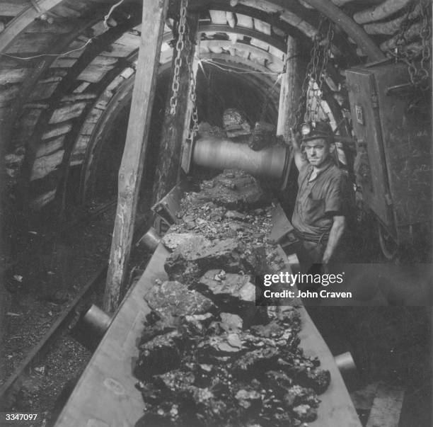 Miner watches coal on an underground conveyor belt in France.
