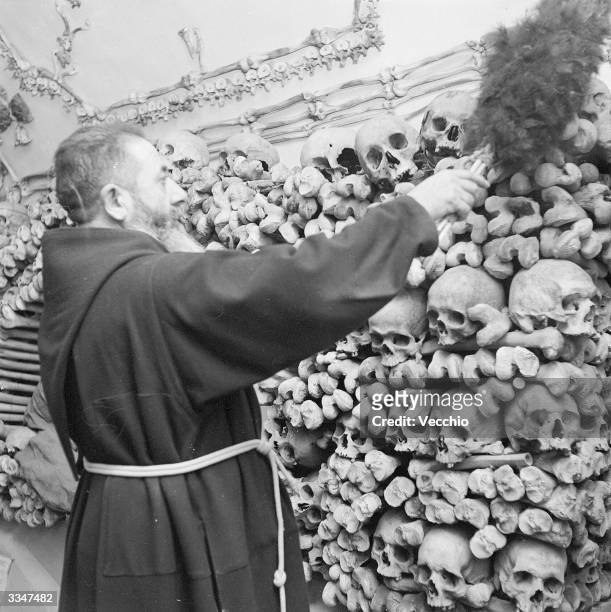Monk dusts down the remains of his dead comrades in the tombs and the catacombs of a Capuchin monastery in Rome.