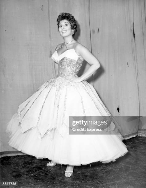 British singer Alma Cogan , wearing a full-circle evening dress.