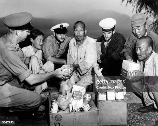 American servicmen giving rations to Japanese civilians during Wirld War II.