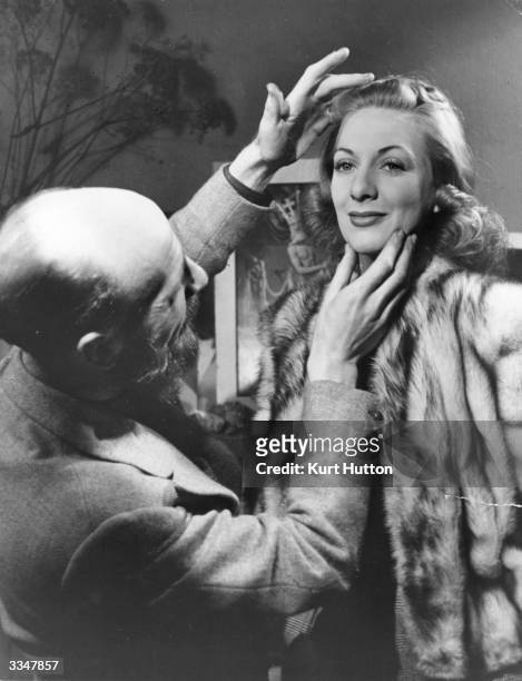 British theatrical portrait photographer Angus McBean positions actress Diana Churchill, in preparation for a photograph. Original Publication:...