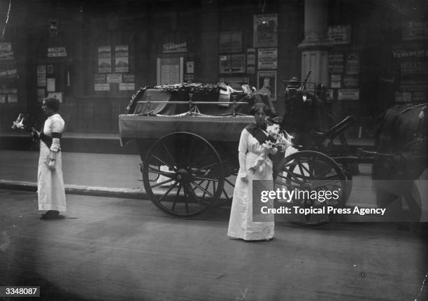 Mrs Yates and Mary Lee guard the coffin of the English suffragette Emily Davison at Victoria Station, London. Davison died after throwing herself...