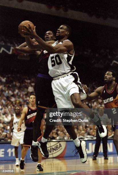 David Robinson of the San Antonio Spurs drives to the basket as Antonio McDyess of the Phoenix Suns tries to block the shot during a first round...