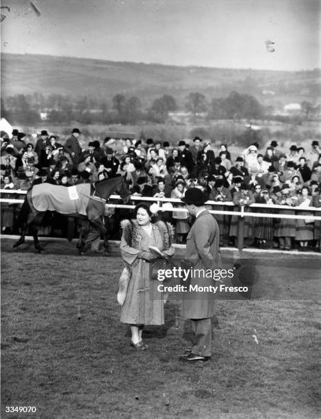 Queen Elizabeth The Queen Mother watching a parade for the National Hunt Steeplechase from within the enclosure at Cheltenham racecourse,...