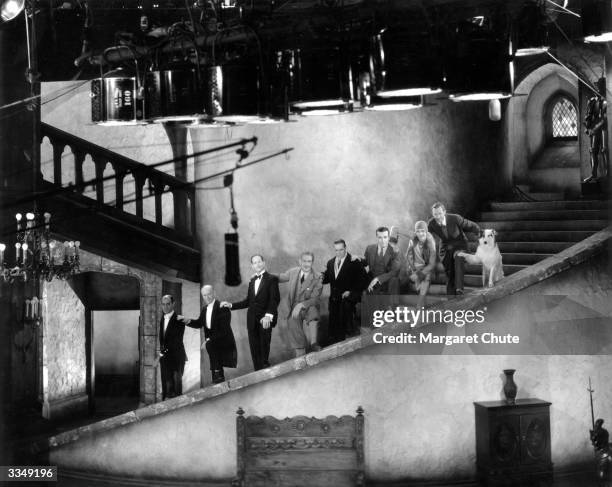 Stars of the Paramount film 'The Insidious Dr Fu Manchu' take a break from filming to pose on the winding stairs of the set. From top to bottom they...