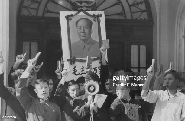 Chinese delegation outside the London's Chinese Embassy holding a portrait of Mao Tse Tung and waving copies of his 'Little Red Book' in the air...