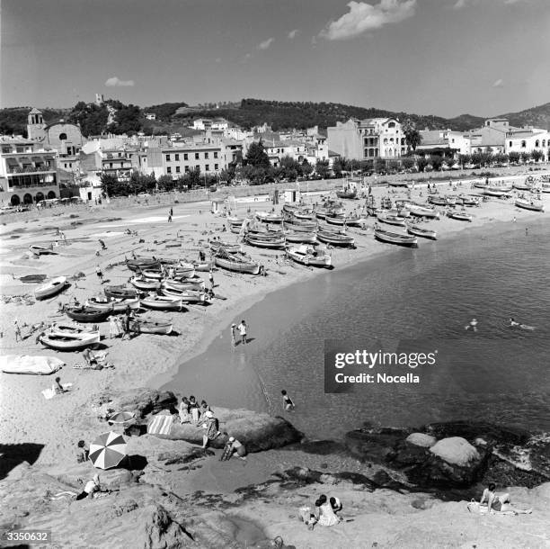 The sandy white beach and the cool blue water of the Mediterranean sea at Tossa De Mar in Spain.